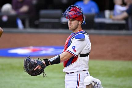 Apr 1, 2023; Arlington, Texas, USA; Texas Rangers catcher Mitch Garver (18) surveys the field during a stoppage in play against the Philadelphia Phillies at Globe Life Field. Mandatory Credit: Jerome Miron-USA TODAY Sports