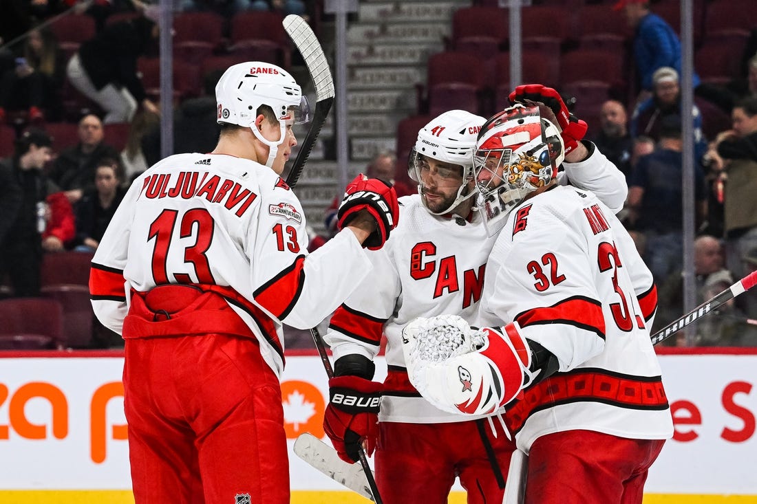 Apr 1, 2023; Montreal, Quebec, CAN; Carolina Hurricanes goalie Antti Raanta (32) celebrates the win against the Montreal Canadiens with right wing Jesse Puljujarvi (13) and defenseman Shayne Gostisbehere (41) after the third period at Bell Centre. Mandatory Credit: David Kirouac-USA TODAY Sports