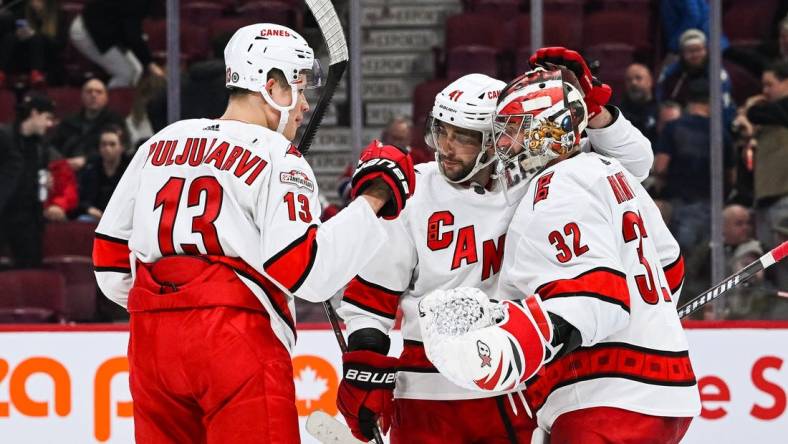 Apr 1, 2023; Montreal, Quebec, CAN; Carolina Hurricanes goalie Antti Raanta (32) celebrates the win against the Montreal Canadiens with right wing Jesse Puljujarvi (13) and defenseman Shayne Gostisbehere (41) after the third period at Bell Centre. Mandatory Credit: David Kirouac-USA TODAY Sports