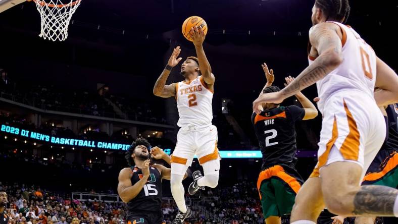 Mar 26, 2023; Kansas City, MO, USA; Texas Longhorns guard Arterio Morris (2) shoots against Miami (Fl) Hurricanes forward Norchad Omier (15) and guard Isaiah Wong (2) during the second half of an Elite 8 college basketball game in the Midwest Regional of the 2023 NCAA Tournament at T-Mobile Center. Mandatory Credit: Jay Biggerstaff-USA TODAY Sports