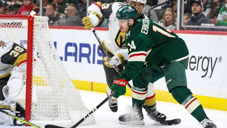 Apr 3, 2023; Saint Paul, Minnesota, USA; Minnesota Wild center Joel Eriksson Ek (14) shoots while Vegas Golden Knights defenseman Alec Martinez (23) defends during the second period at Xcel Energy Center. Mandatory Credit: Matt Krohn-USA TODAY Sports