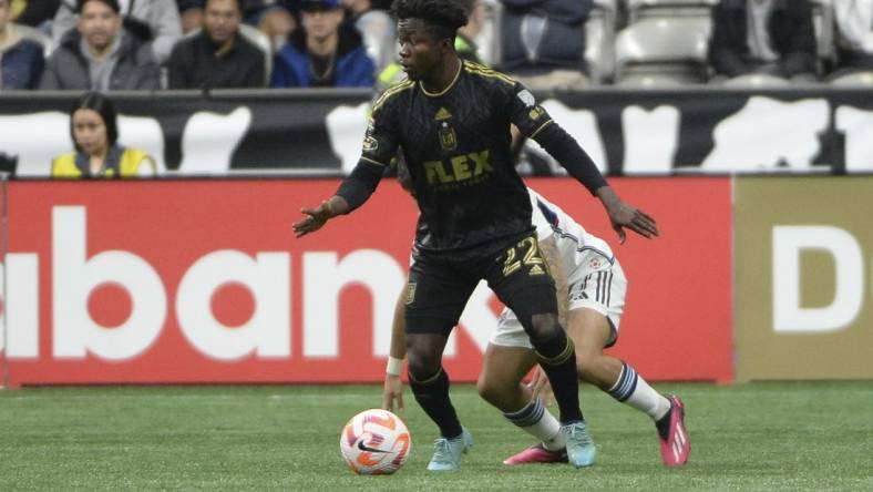 Apr 5, 2023; Vancouver, British Columbia, CAN;  Los Angeles FC forward Kwadwo Opoku (22) takes possession of the ball against Vancouver Whitecaps FC defender Ryan Raposo (27) during the first half at BC Place. Mandatory Credit: Anne-Marie Sorvin-USA TODAY Sports