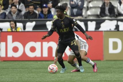 Apr 5, 2023; Vancouver, British Columbia, CAN;  Los Angeles FC forward Kwadwo Opoku (22) takes possession of the ball against Vancouver Whitecaps FC defender Ryan Raposo (27) during the first half at BC Place. Mandatory Credit: Anne-Marie Sorvin-USA TODAY Sports