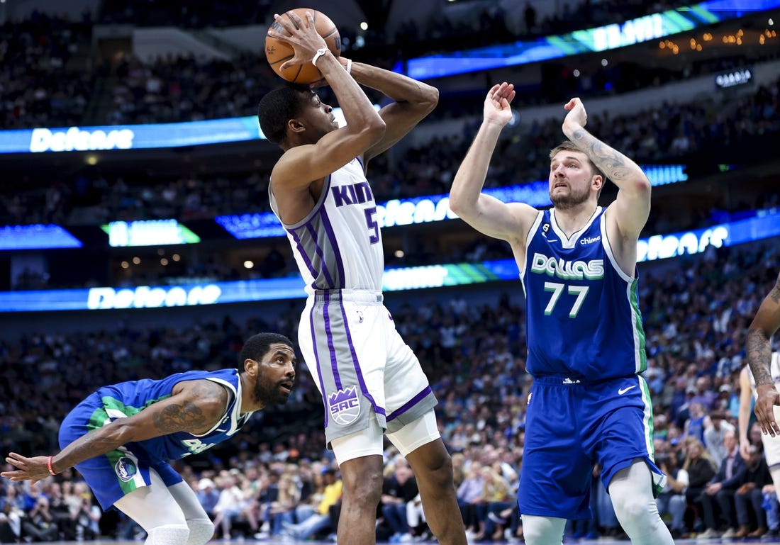 Apr 5, 2023; Dallas, Texas, USA;  Sacramento Kings guard De'Aaron Fox (5) shoots as Dallas Mavericks guard Kyrie Irving (2) and Dallas Mavericks guard Luka Doncic (77) defend during the fourth quarter at American Airlines Center. Mandatory Credit: Kevin Jairaj-USA TODAY Sports