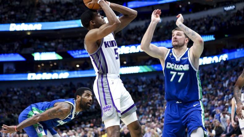 Apr 5, 2023; Dallas, Texas, USA;  Sacramento Kings guard De'Aaron Fox (5) shoots as Dallas Mavericks guard Kyrie Irving (2) and Dallas Mavericks guard Luka Doncic (77) defend during the fourth quarter at American Airlines Center. Mandatory Credit: Kevin Jairaj-USA TODAY Sports