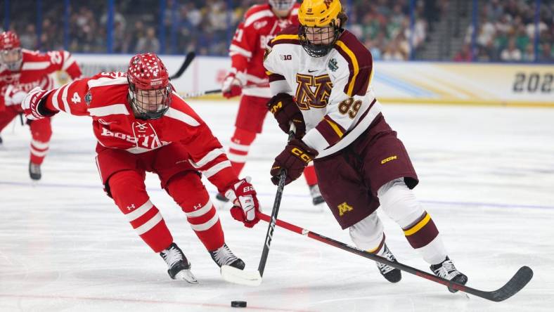 Apr 6, 2023; Tampa, Florida, USA; Minnesota forward Matthew Knies (89) controls the puck from Boston University defenseman Ty Gallagher (4) in the first period in the semifinals of the 2023 Frozen Four college ice hockey tournament at Amalie Arena. Mandatory Credit: Nathan Ray Seebeck-USA TODAY Sports