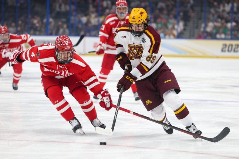 Apr 6, 2023; Tampa, Florida, USA; Minnesota forward Matthew Knies (89) controls the puck from Boston University defenseman Ty Gallagher (4) in the first period in the semifinals of the 2023 Frozen Four college ice hockey tournament at Amalie Arena. Mandatory Credit: Nathan Ray Seebeck-USA TODAY Sports