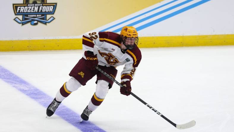 Apr 6, 2023; Tampa, Florida, USA; Minnesota forward Logan Cooley (92) controls the puck against Boston University during the second period in the semifinals of the 2023 Frozen Four college ice hockey tournament at Amalie Arena. Mandatory Credit: Nathan Ray Seebeck-USA TODAY Sports