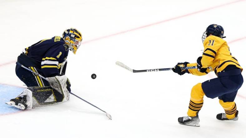 Apr 6, 2023; Tampa, Florida, USA; Quinnipiac forward Collin Graf (11) shoots the puck on Michigan goaltender Erik Portillo (1) during the second period in the semifinals of the 2023 Frozen Four college ice hockey tournament at Amalie Arena. Mandatory Credit: Nathan Ray Seebeck-USA TODAY Sports