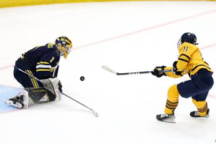 Apr 6, 2023; Tampa, Florida, USA; Quinnipiac forward Collin Graf (11) shoots the puck on Michigan goaltender Erik Portillo (1) during the second period in the semifinals of the 2023 Frozen Four college ice hockey tournament at Amalie Arena. Mandatory Credit: Nathan Ray Seebeck-USA TODAY Sports