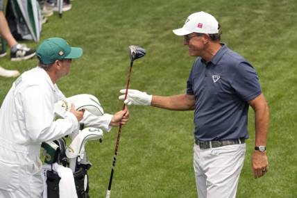 Apr 7, 2023; Augusta, Georgia, USA; Phil Mickelson hands his driver to caddie Tim Mickelson on the 18th tee box during the second round of The Masters golf tournament. Mandatory Credit: Michael Madrid-USA TODAY Network