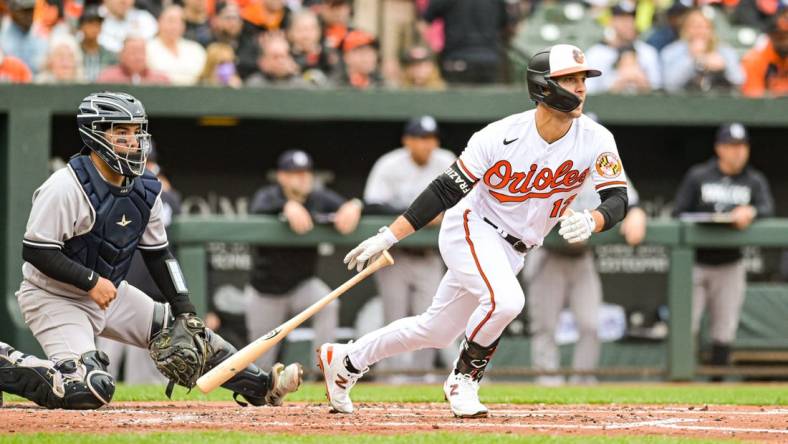 Apr 7, 2023; Baltimore, Maryland, USA; Baltimore Orioles second baseman Adam Frazier (12) hits a  second inning rbi single against the New York Yankees at Oriole Park at Camden Yards. Mandatory Credit: Tommy Gilligan-USA TODAY Sports