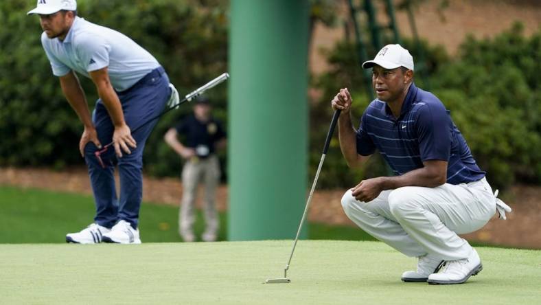 Apr 7, 2023; Augusta, Georgia, USA; Xander Schauffele and Tiger Woods line up putts on the tenth green during the second round of The Masters golf tournament. Mandatory Credit: Danielle Parhizkaran-USA TODAY Network