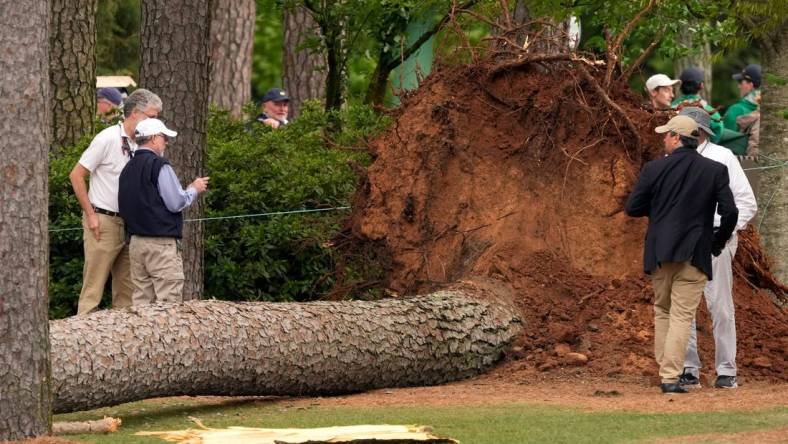 Volunteers and staff secure the area around where a tree fell near the 17th tee.

Pga Masters Tournament Second Round