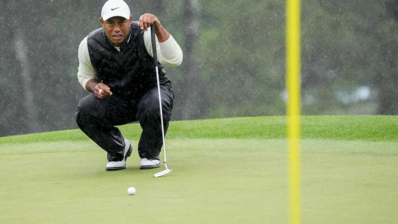 Apr 8, 2023; Augusta, Georgia, USA; Tiger Woods lines up his putt on the 18th green during the second round of The Masters golf tournament. Mandatory Credit: Rob Schumacher-USA TODAY Network