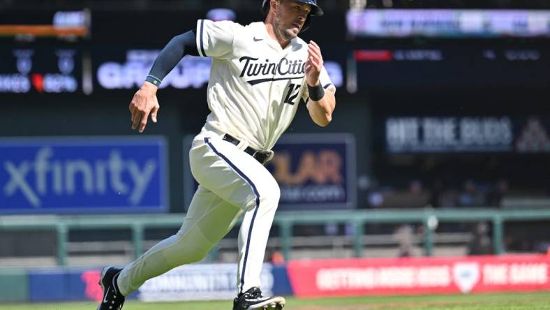 Apr 8, 2023; Minneapolis, Minnesota, USA; Minnesota Twins third baseman Kyle Farmer (12) scores on a single by catcher Christian Vazquez (not pictured) during the sixth inning against the Houston Astros at Target Field. Mandatory Credit: Jeffrey Becker-USA TODAY Sports