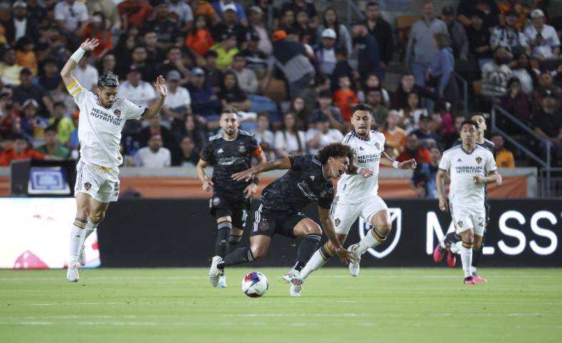 Apr 8, 2023; Houston, Texas, USA; Houston Dynamo FC midfielder Adalberto Carrasquilla (20) and LA Galaxy midfielder Marco Delgado (8) battle for the ball during the first half at Shell Energy Stadium. Mandatory Credit: Troy Taormina-USA TODAY Sports