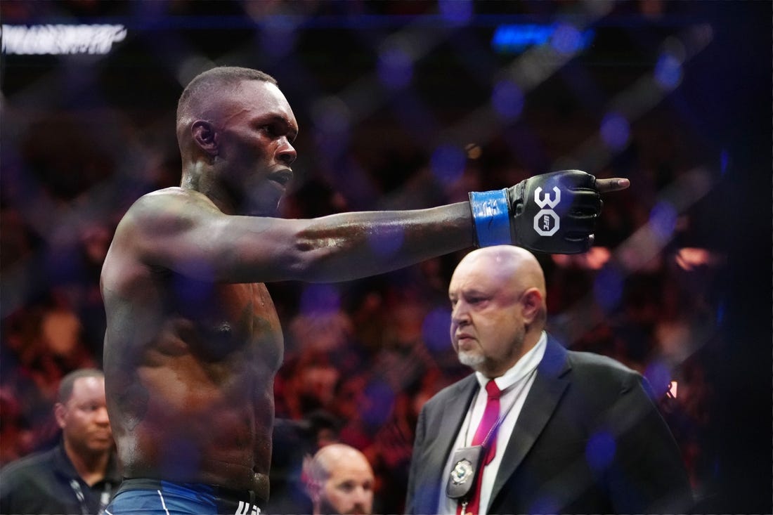 Apr 8, 2023; Miami, Florida, USA; Israel Adesanya (blue gloves) reacts to defeating Alex Pereira (red gloves) during UFC 287 at Miami-Dade Arena. Mandatory Credit: Rich Storry-USA TODAY Sports