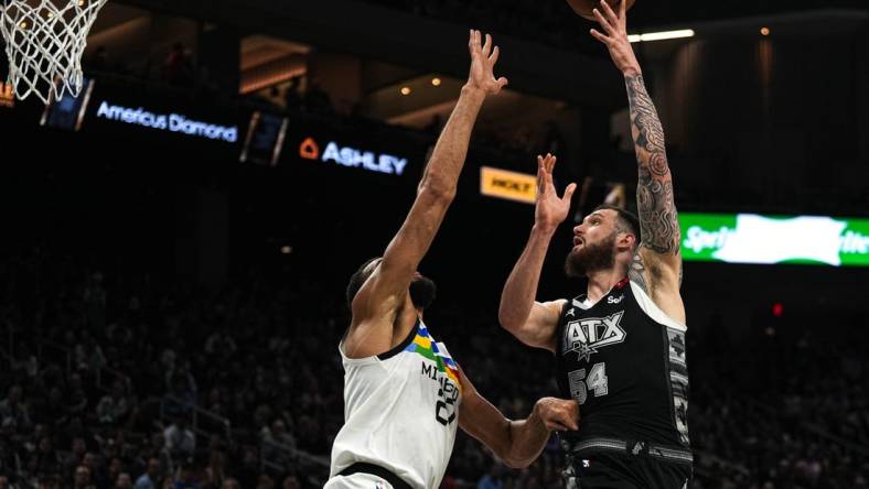 April 8, 2023; Austin, TX, USA; San Antonio Spurs forward Sandro Mamukelashvili (54) shoots over Minnesota Timberwolves center Rudy Gobert (27) during the game at the Moody Center on Saturday, April 8, 2023 in Austin. Mandatory Credit: Aaron E. Martinez-USA TODAY NETWORK