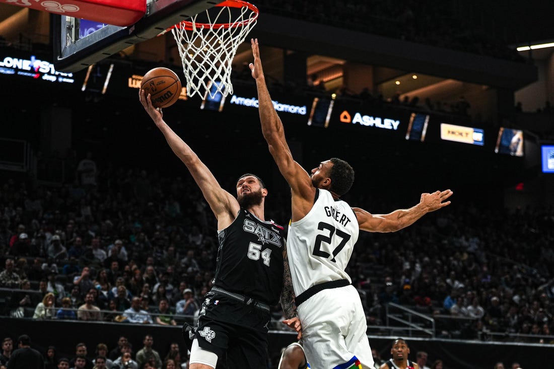 April 8, 2023; Austin, TX, USA; San Antonio Spurs forward Sandro Mamukelashvili (54) shoots past Minnesota Timberwolves center Rudy Gobert (27) during the game at the Moody Center on Saturday, April 8, 2023 in Austin. Mandatory Credit: Aaron E. Martinez-USA TODAY NETWORK