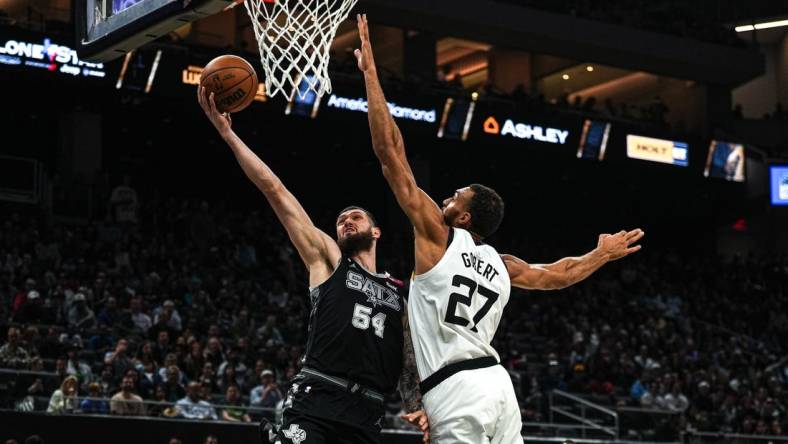 April 8, 2023; Austin, TX, USA; San Antonio Spurs forward Sandro Mamukelashvili (54) shoots past Minnesota Timberwolves center Rudy Gobert (27) during the game at the Moody Center on Saturday, April 8, 2023 in Austin. Mandatory Credit: Aaron E. Martinez-USA TODAY NETWORK