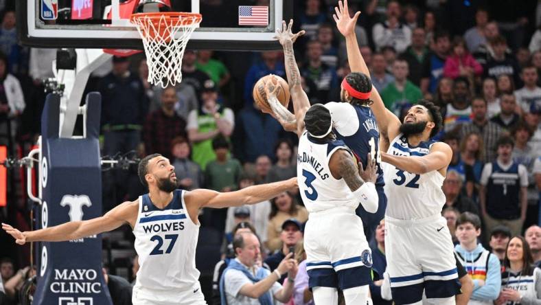 Apr 9, 2023; Minneapolis, Minnesota, USA; New Orleans Pelicans forward Brandon Ingram (14) goes to the basket as Minnesota Timberwolves center Karl-Anthony Towns (32), forward Jaden McDaniels (3) and center Rudy Gobert (27) defend during the first quarter at Target Center. Mandatory Credit: Jeffrey Becker-USA TODAY Sports