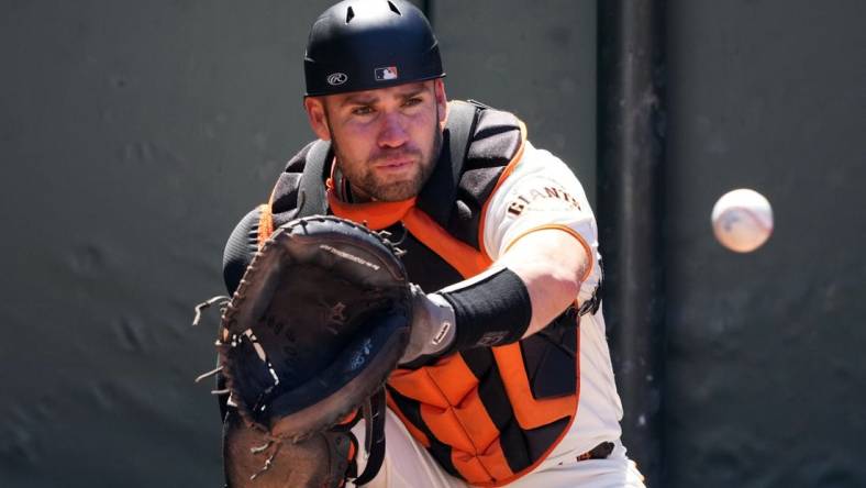 Apr 9, 2023; San Francisco, California, USA; San Francisco Giants catcher Austin Wynns (14) warms up before the game against the Kansas City Royals at Oracle Park. Mandatory Credit: Darren Yamashita-USA TODAY Sports