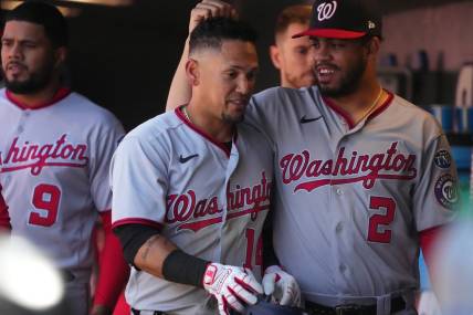 Apr 9, 2023; Denver, Colorado, USA; Washington Nationals second baseman Ildemaro Vargas (14) celebrates walking in a run with infielder Luis Garcia (2) in the sixth inning against the Colorado Rockies at Coors Field. Mandatory Credit: Ron Chenoy-USA TODAY Sports
