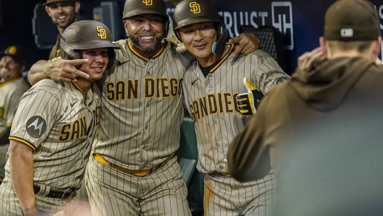 Apr 9, 2023; Cumberland, Georgia, USA; San Diego Padres second baseman Ha-Seong Kim (7) (right) gets a photo in the dugout with designated hitter Nelson Cruz (32) (center) and a bat boy after hitting a home run against the Atlanta Braves during the fifth inning at Truist Park. Mandatory Credit: Dale Zanine-USA TODAY Sports