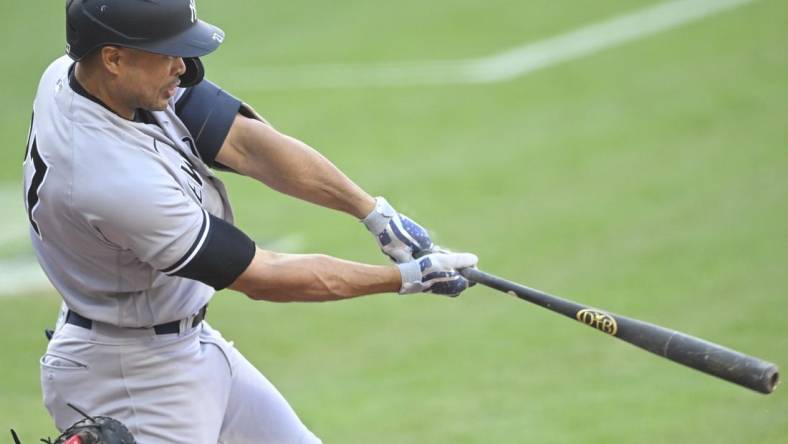 Apr 10, 2023; Cleveland, Ohio, USA; New York Yankees right fielder Giancarlo Stanton (27) hits a two-RBI double in the first inning against the Cleveland Guardians at Progressive Field. Mandatory Credit: David Richard-USA TODAY Sports