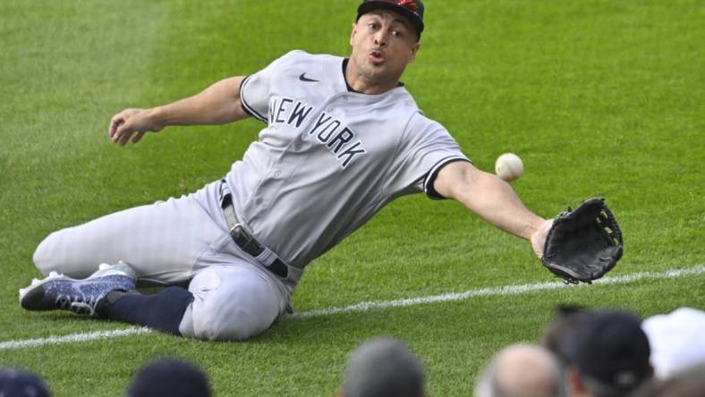 Apr 10, 2023; Cleveland, Ohio, USA; New York Yankees right fielder Giancarlo Stanton (27) reaches for a ball that landed foul in the second inning against the Cleveland Guardians at Progressive Field. Mandatory Credit: David Richard-USA TODAY Sports