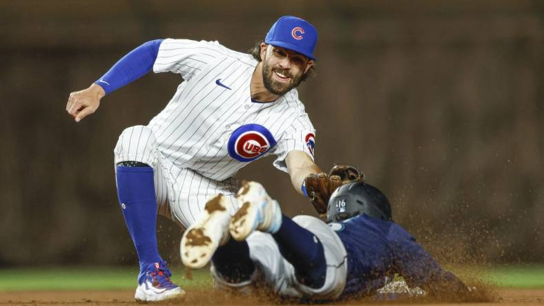 Apr 10, 2023; Chicago, Illinois, USA; Chicago Cubs shortstop Dansby Swanson (7) tags out Seattle Mariners second baseman Kolten Wong (16) as he tries to steal second base during the ninth inning at Wrigley Field. Mandatory Credit: Kamil Krzaczynski-USA TODAY Sports