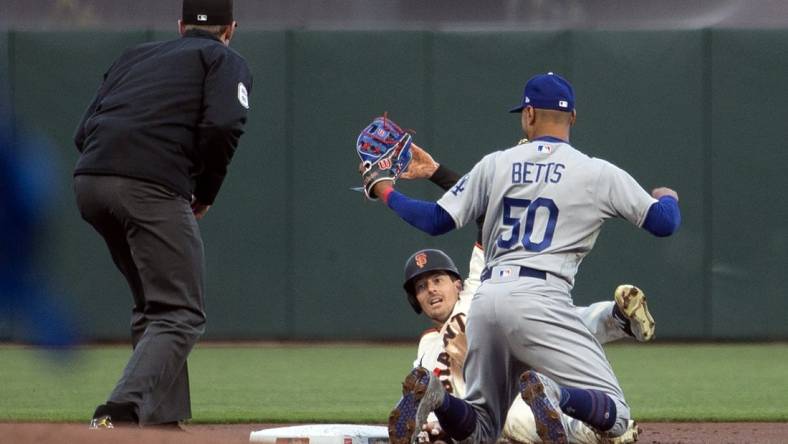 Apr 10, 2023; San Francisco, California, USA; Los Angeles Dodgers second baseman Mookie Betts (50) tags out San Francisco Giants right fielder Mike Yastrzemski (5) as he is caught attempting to steal second base during the first inning at Oracle Park. Umpire is Alex Tosi. Mandatory Credit: D. Ross Cameron-USA TODAY Sports