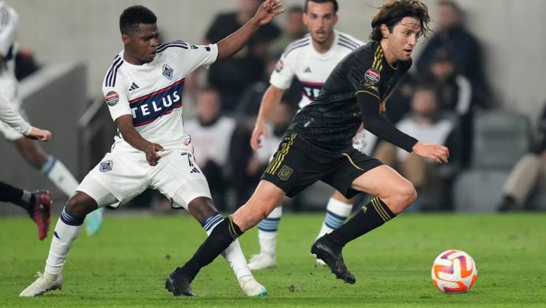 Apr 11, 2023; Los Angeles, CA, USA; LAFC midfielder Ilie Sanchez (6) and Vancouver Whitecaps forward Deiber Caicedo (7) battle for the ball in the first half at BMO Stadium. Mandatory Credit: Kirby Lee-USA TODAY Sports