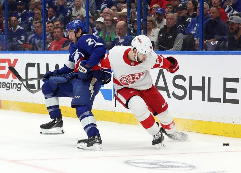 Apr 13, 2023; Tampa, Florida, USA; Tampa Bay Lightning center Brayden Point (21) and Detroit Red Wings defenseman Jake Walman (96) play for the puck during the first period at Amalie Arena. Mandatory Credit: Kim Klement-USA TODAY Sports