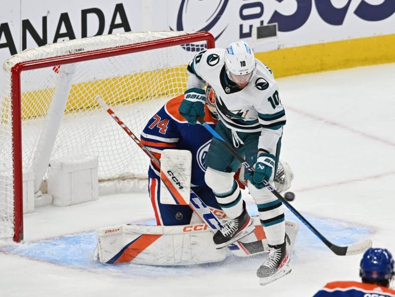 Apr 13, 2023; Edmonton, Alberta, CAN;   Edmonton Oilers goalie Stuart Skinner (74) battles for the puck with  San Jose Sharks left winger Evgeny Svechnikov (10) during the first period at Rogers Place. Mandatory Credit: Walter Tychnowicz-USA TODAY Sports