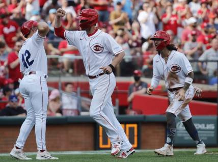 Apr 15, 2023; Cincinnati, Ohio, USA; Cincinnati Reds first baseman Wil Myers (middle) reacts with third baseman Spencer Steer (left) and second baseman Jonathan India (right) after hitting a three-run home run against the Philadelphia Phillies during the third inning at Great American Ball Park. Mandatory Credit: David Kohl-USA TODAY Sports