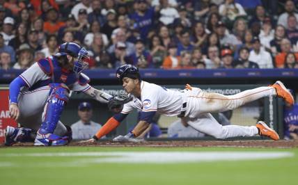 Apr 15, 2023; Houston, Texas, USA; Houston Astros shortstop Jeremy Pena slides safely to score a run as Texas Rangers catcher Jonah Heim attempts to apply a tag during the fourth inning at Minute Maid Park. Mandatory Credit: Troy Taormina-USA TODAY Sports