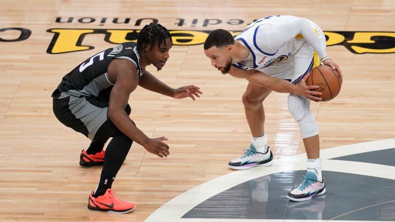 Apr 15, 2023; Sacramento, California, USA; Golden State Warriors guard Stephen Curry (30) holds onto the ball next to Sacramento Kings guard Davion Mitchell (15) in the second quarter during game one of the 2023 NBA playoffs at the Golden 1 Center. Mandatory Credit: Cary Edmondson-USA TODAY Sports