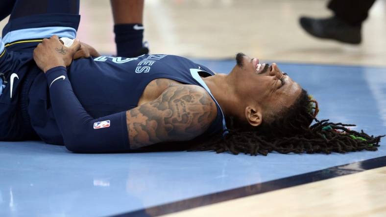 Apr 16, 2023; Memphis, Tennessee, USA; Memphis Grizzlies guard Ja Morant (12)reacts after falling to the ground during the second half during game one of the 2023 NBA playoffs against the Los Angeles Lakers at FedExForum. Mandatory Credit: Petre Thomas-USA TODAY Sports