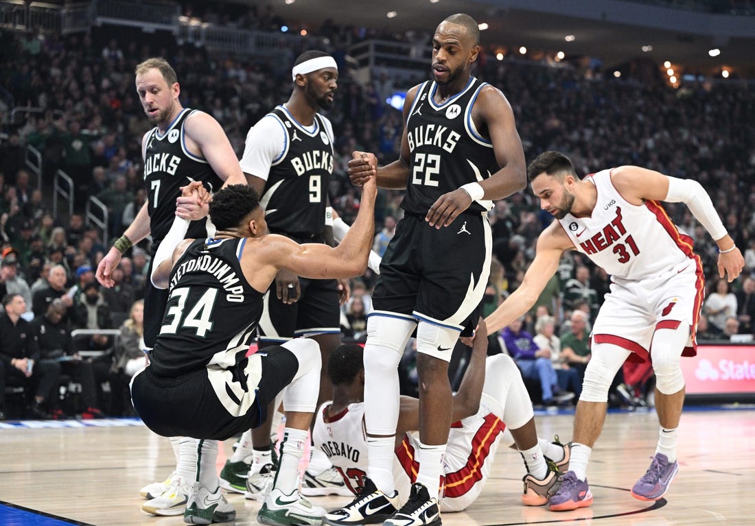 Apr 16, 2023; Milwaukee, Wisconsin, USA; Milwaukee Bucks forward Giannis Antetokounmpo (34) is helped up after a collision in the first half against Miami Heat center Bam Adebayo (13) during game one of the 2023 NBA Playoffs at Fiserv Forum. Mandatory Credit: Michael McLoone-USA TODAY Sports