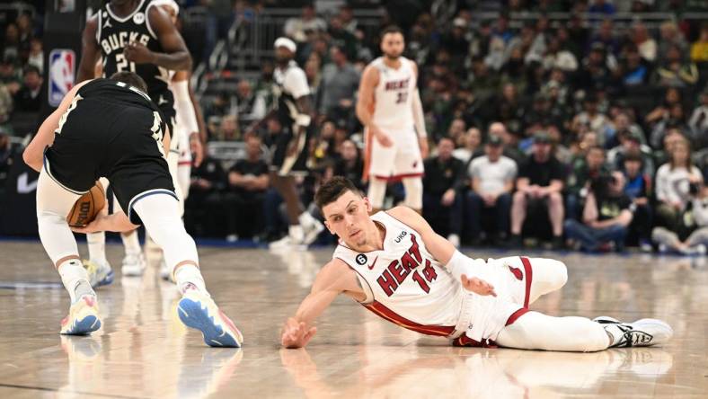 Apr 16, 2023; Milwaukee, Wisconsin, USA; Miami Heat guard Tyler Herro (14) injures his hand while diving for a loose ball against the Milwaukee Bucks during game one of the 2023 NBA Playoffs at Fiserv Forum. Mandatory Credit: Michael McLoone-USA TODAY Sports