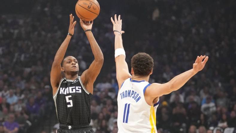 April 17, 2023; Sacramento, California, USA; Sacramento Kings guard De'Aaron Fox (5) shoots the basketball against Golden State Warriors guard Klay Thompson (11) during the first quarter in game two of the first round of the 2023 NBA playoffs at Golden 1 Center. Mandatory Credit: Kyle Terada-USA TODAY Sports