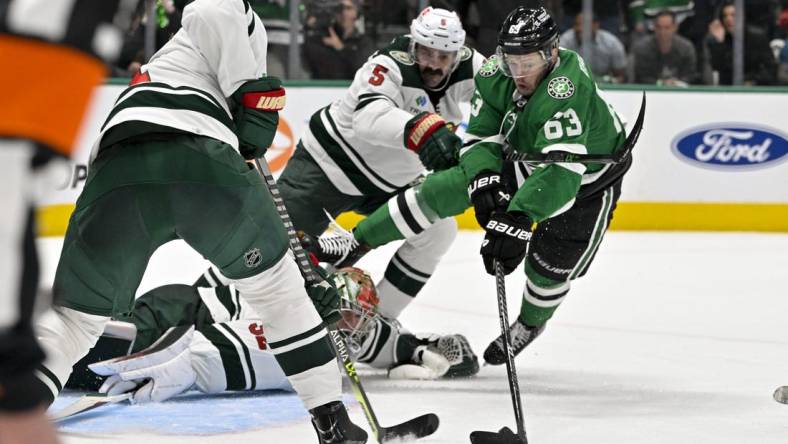 Apr 17, 2023; Dallas, Texas, USA; Minnesota Wild defenseman Jake Middleton (5) checks Dallas Stars right wing Evgenii Dadonov (63) as he attempts to poke the puck past goaltender Filip Gustavsson (32) during the first overtime period in game one of the first round of the 2023 Stanley Cup Playoffs at the American Airlines Center. Mandatory Credit: Jerome Miron-USA TODAY Sports