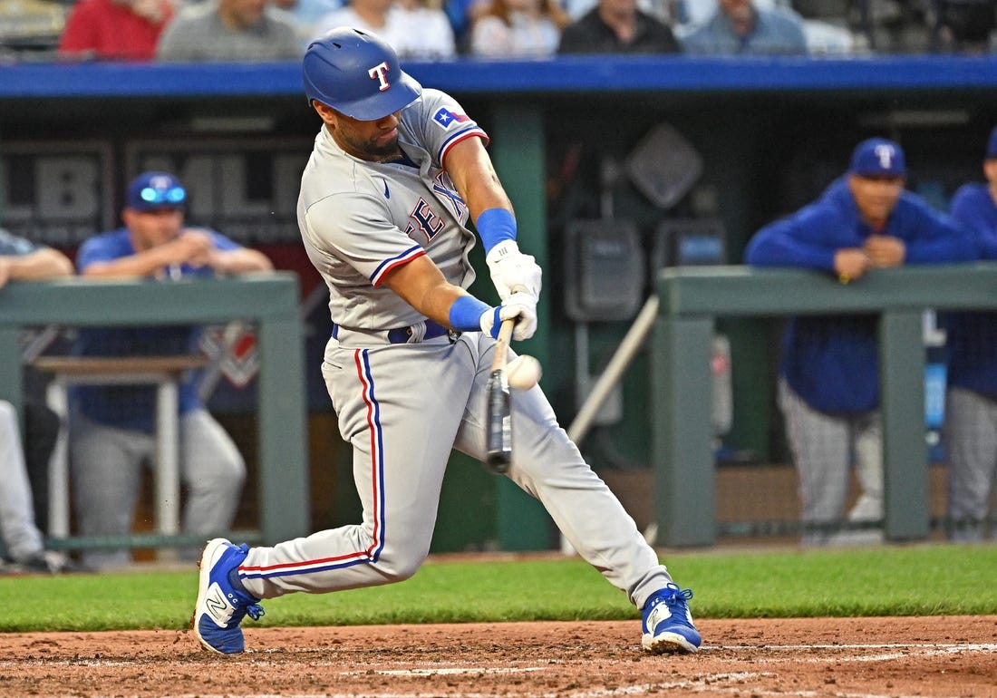 Apr 18, 2023; Kansas City, Missouri, USA; Texas Rangers shortstop Ezequiel Duran (20) hits an RBI single during the fourth inning against the Kansas City Royals at Kauffman Stadium. Mandatory Credit: Peter Aiken-USA TODAY Sports