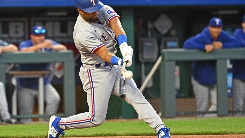 Apr 18, 2023; Kansas City, Missouri, USA; Texas Rangers shortstop Ezequiel Duran (20) hits an RBI single during the fourth inning against the Kansas City Royals at Kauffman Stadium. Mandatory Credit: Peter Aiken-USA TODAY Sports