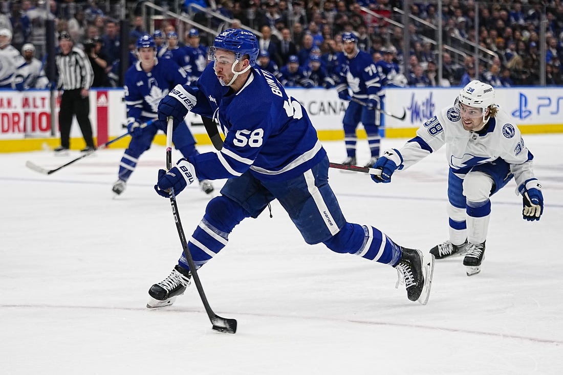 Apr 18, 2023; Toronto, Ontario, CAN; Toronto Maple Leafs forward Michael Bunting (58) shoots the puck as Tampa Bay Lightning forward Brandon Hagel (38) closes in during the first period of game one of the first round of the 2023 Stanley Cup Playoffs at Scotiabank Arena. Mandatory Credit: John E. Sokolowski-USA TODAY Sports