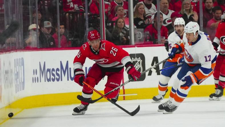 Apr 19, 2023; Raleigh, North Carolina, USA; Carolina Hurricanes center Paul Stastny (26) and New York Islanders left wing Matt Martin (17) chase after the puck during the first period in game two of the first round of the 2023 Stanley Cup Playoffs at PNC Arena. Mandatory Credit: James Guillory-USA TODAY Sports