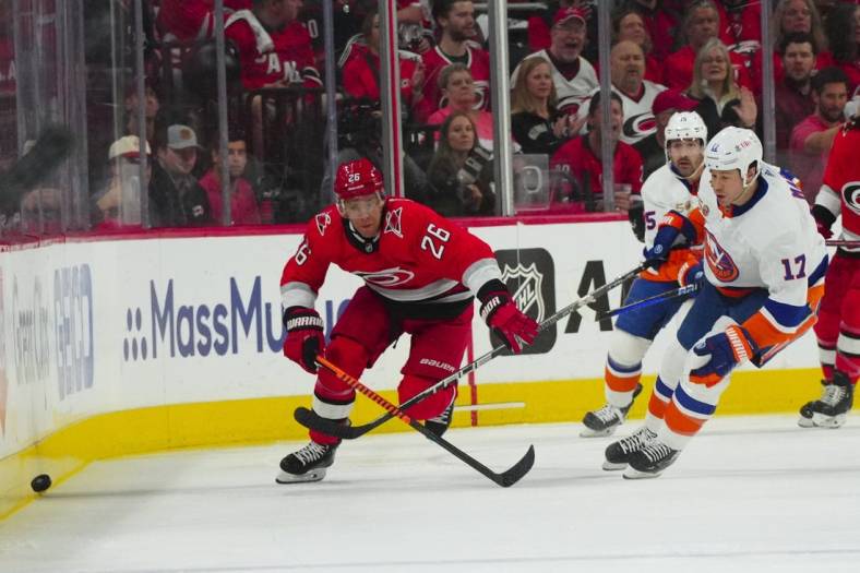Apr 19, 2023; Raleigh, North Carolina, USA; Carolina Hurricanes center Paul Stastny (26) and New York Islanders left wing Matt Martin (17) chase after the puck during the first period in game two of the first round of the 2023 Stanley Cup Playoffs at PNC Arena. Mandatory Credit: James Guillory-USA TODAY Sports