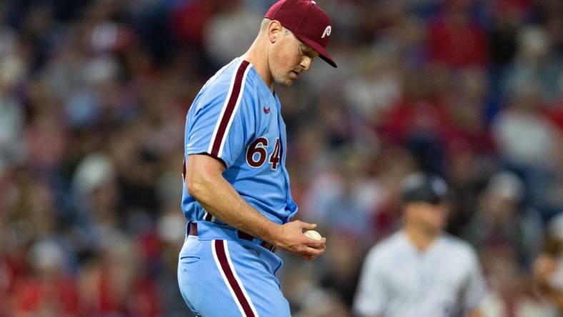 Apr 20, 2023; Philadelphia, Pennsylvania, USA; Philadelphia Phillies relief pitcher Andrew Bellatti (64) looks at the ball after walking in a run during the sixth inning against the Colorado Rockies at Citizens Bank Park. Mandatory Credit: Bill Streicher-USA TODAY Sports